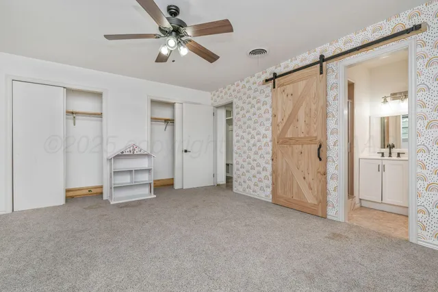 a view of a livingroom with closet & a ceiling fan