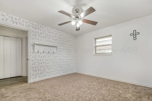 an empty room with windows and ceiling fan