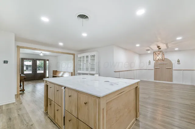 a hall with kitchen island a sink dishwasher a stove and a refrigerator with wooden floor