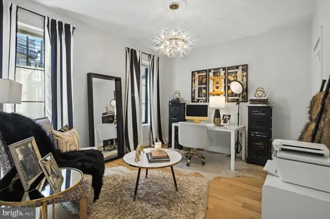 a bedroom with a bed television on dresser and a window
