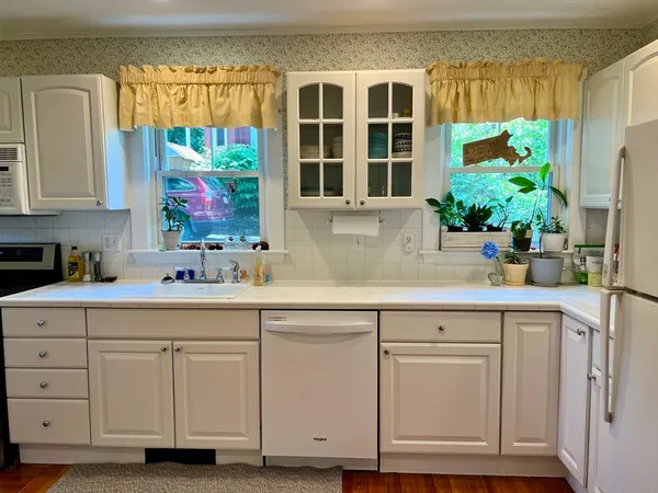 a kitchen with white cabinets and sink