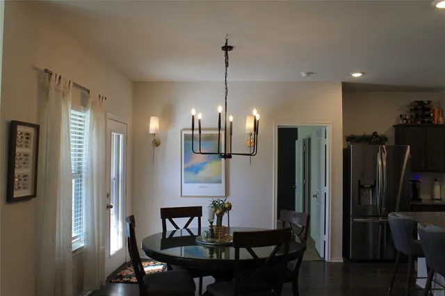 a kitchen with stainless steel appliances kitchen island granite countertop a dining table chairs stove a refrigerator and a kitchen island