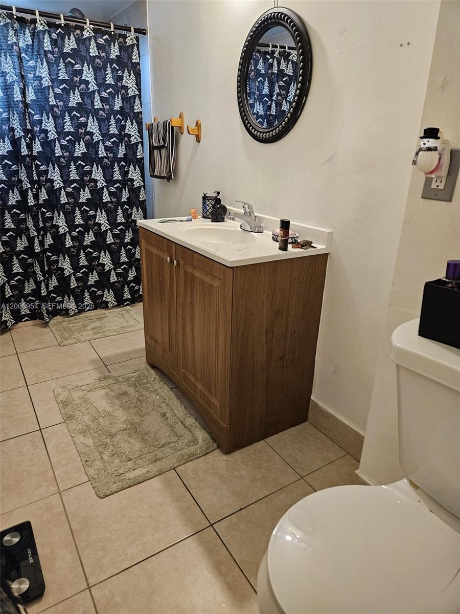 8620 Southwest 149th Avenue, Unit 418 Miami, FL 33193 - Photo 2 of 9 a bathroom with a sink a toilet and a mirror