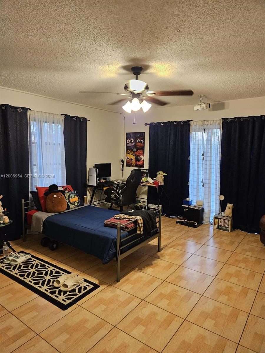 8620 Southwest 149th Avenue, Unit 418 Miami, FL 33193 - Photo 4 of 9 a living room with furniture a table and a flat screen tv