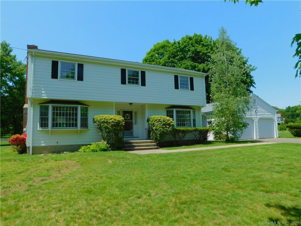 a front view of a house with a yard and trees