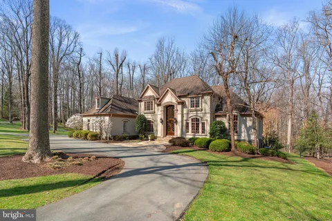 a front view of a house with a yard and trees