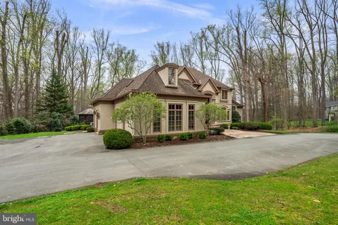 a front view of a house with a yard and potted plants