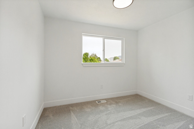 62 South Clark Lane Elk Ridge, UT 84651 - Photo 16 of 30 Bright 3rd bedroom featuring a window with white trim, light gray carpet, white walls, and a flush-mount ceiling light