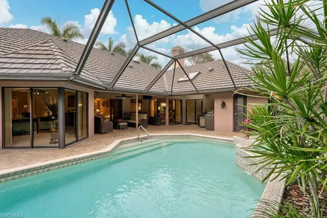 a view of a house with pool and chairs