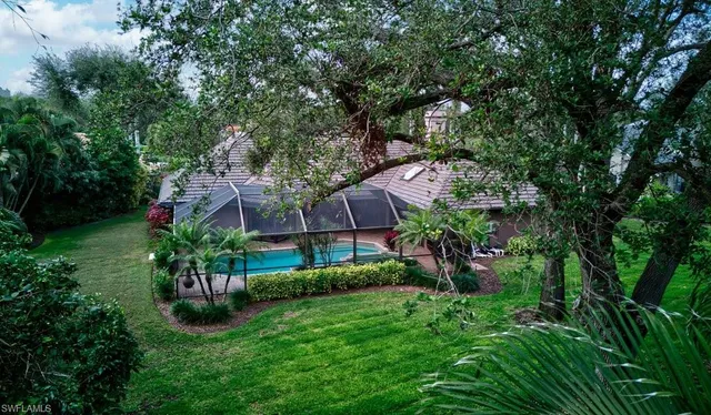 a view of a garden with a tree in front of the house