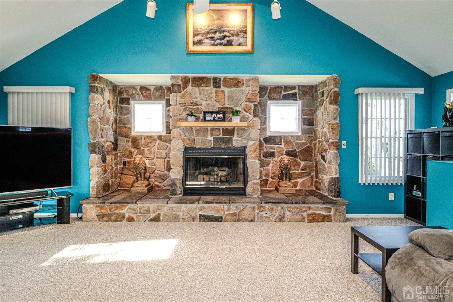 134 Normandy Road Colonia, NJ 07067 - Photo 12 of 45 a living room with fireplace furniture and a flat screen tv