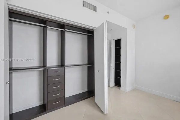 a view of walk in closet with empty racks