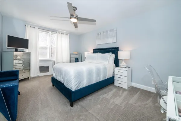 a bedroom with a bed and a flat tv screen on the dresser