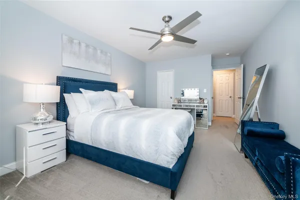 a bedroom with a bed and a lamp on the dresser