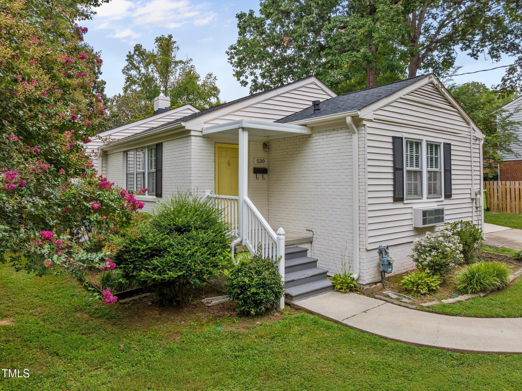 530 Banks Street Raleigh, NC 27604 - Photo 2 of 50 a view of a white house with a small yard and potted plants