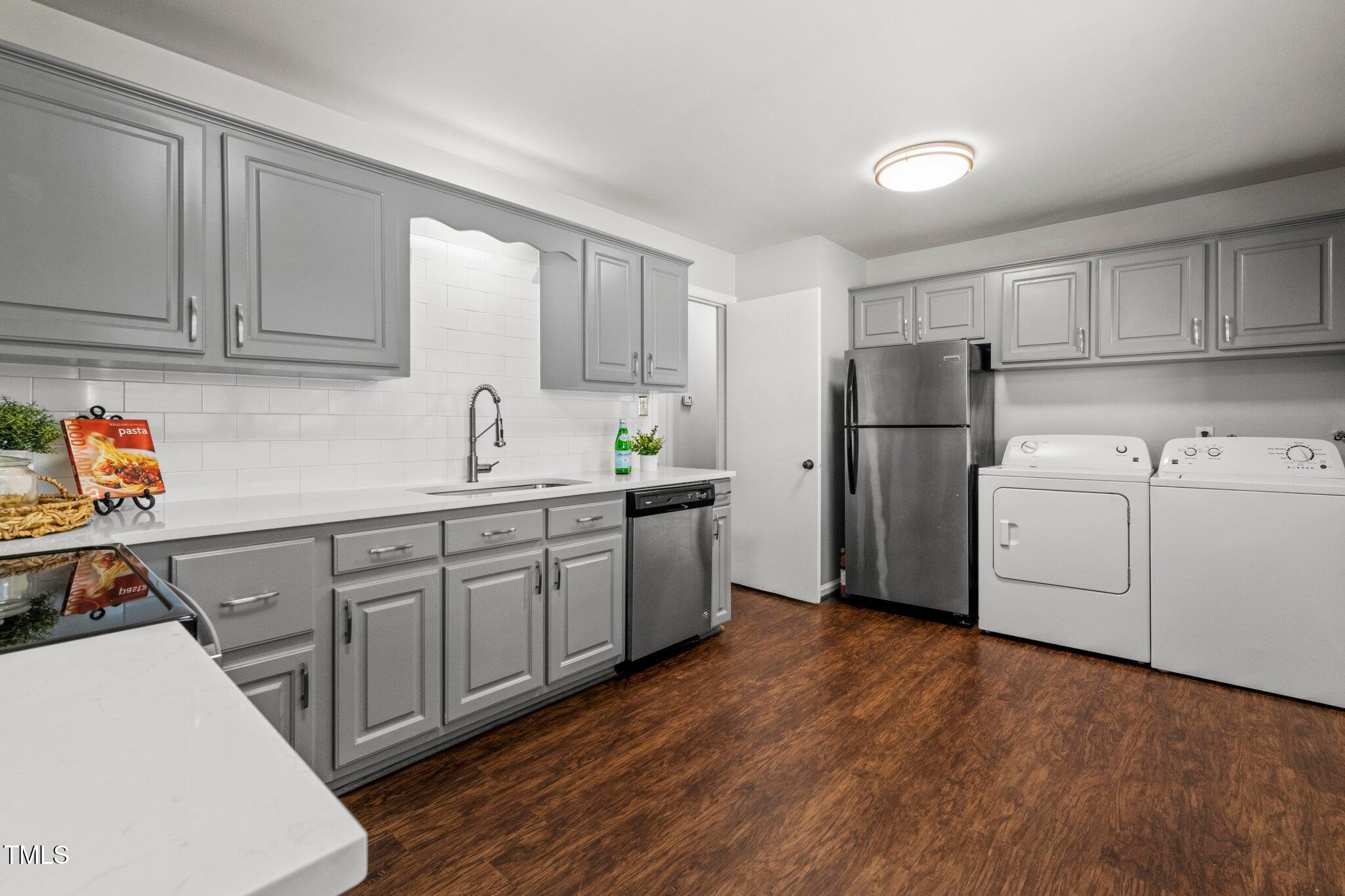 530 Banks Street Raleigh, NC 27604 - Photo 10 of 50 a kitchen with a sink a refrigerator and cabinets