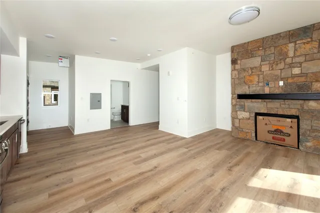 a view of empty room with wooden floor and fireplace