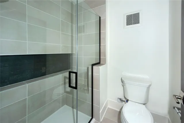 a bathroom with a toilet and a shower