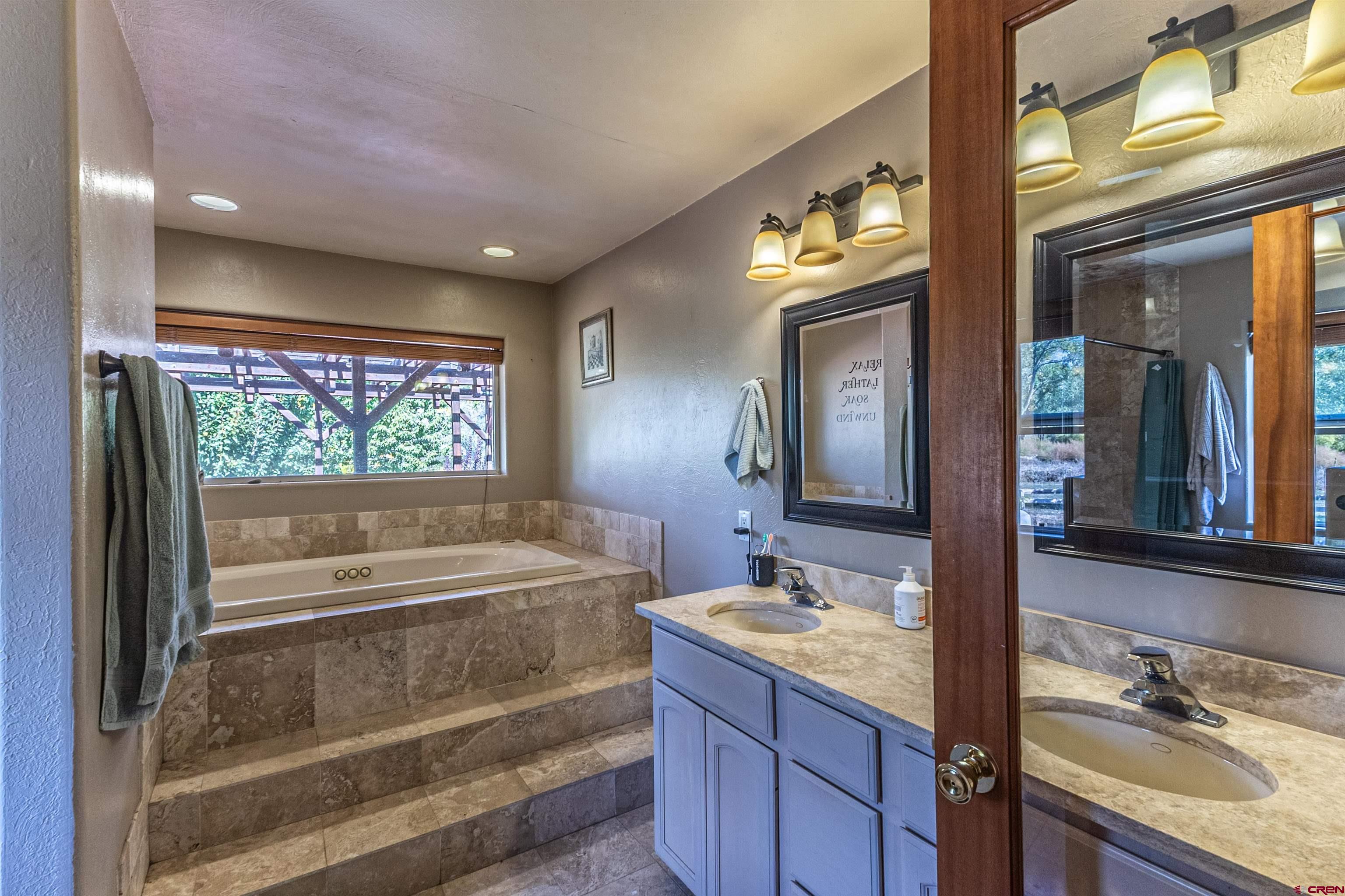 18 Road 2617 Aztec, NM 87410 - Photo 19 of 45 a bathroom with a tub a sink and mirror