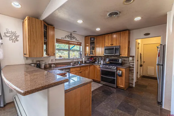 a kitchen with stainless steel appliances granite countertop a stove a sink and a refrigerator