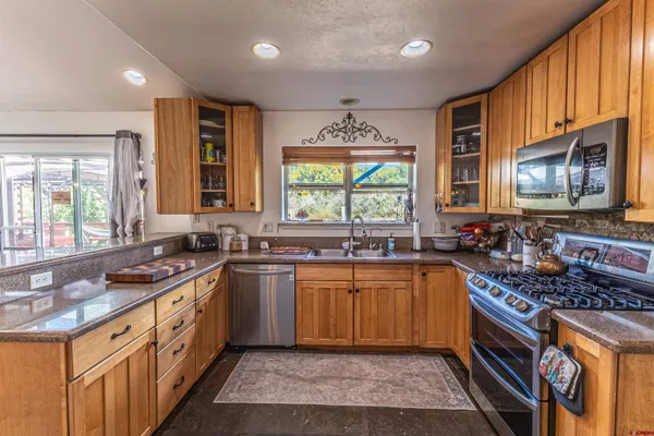 a kitchen with stainless steel appliances sink stove microwave and cabinets