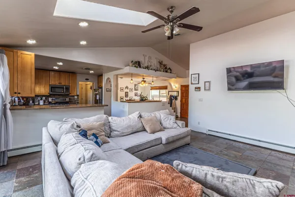 a living room with furniture and a view of kitchen