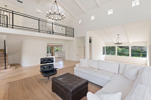 a living room with furniture a fireplace and a floor to ceiling window