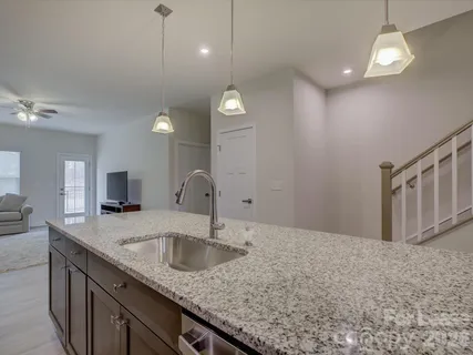 a kitchen with sink cabinets and chandelier