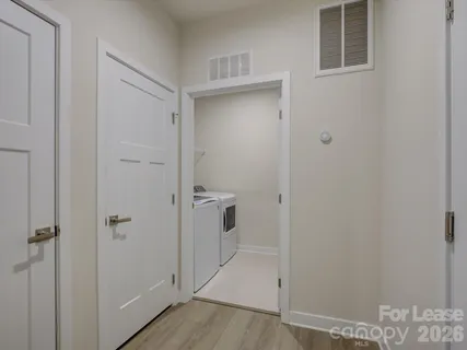 a view of a hallway with closet and wooden floor