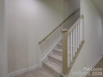a view of staircase with wooden floor and white walls