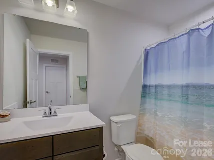a bathroom with a sink vanity mirror and toilet