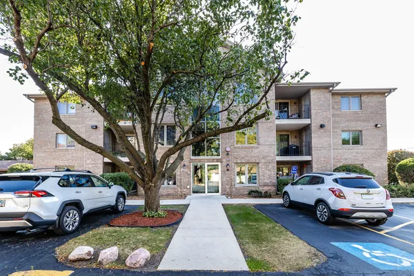 a white house that has a tree in front of it