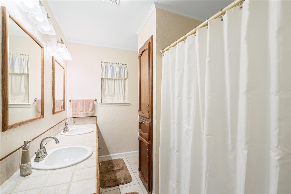 20 Saddle Rock Ridge Street Wimberley, TX 78676 - Photo 19 of 40 a bathroom with a sink a mirror and a shower