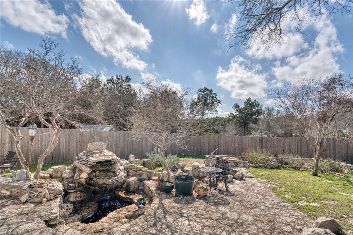 20 Saddle Rock Ridge Street Wimberley, TX 78676 - Photo 30 of 40 a backyard of a house with table and chairs