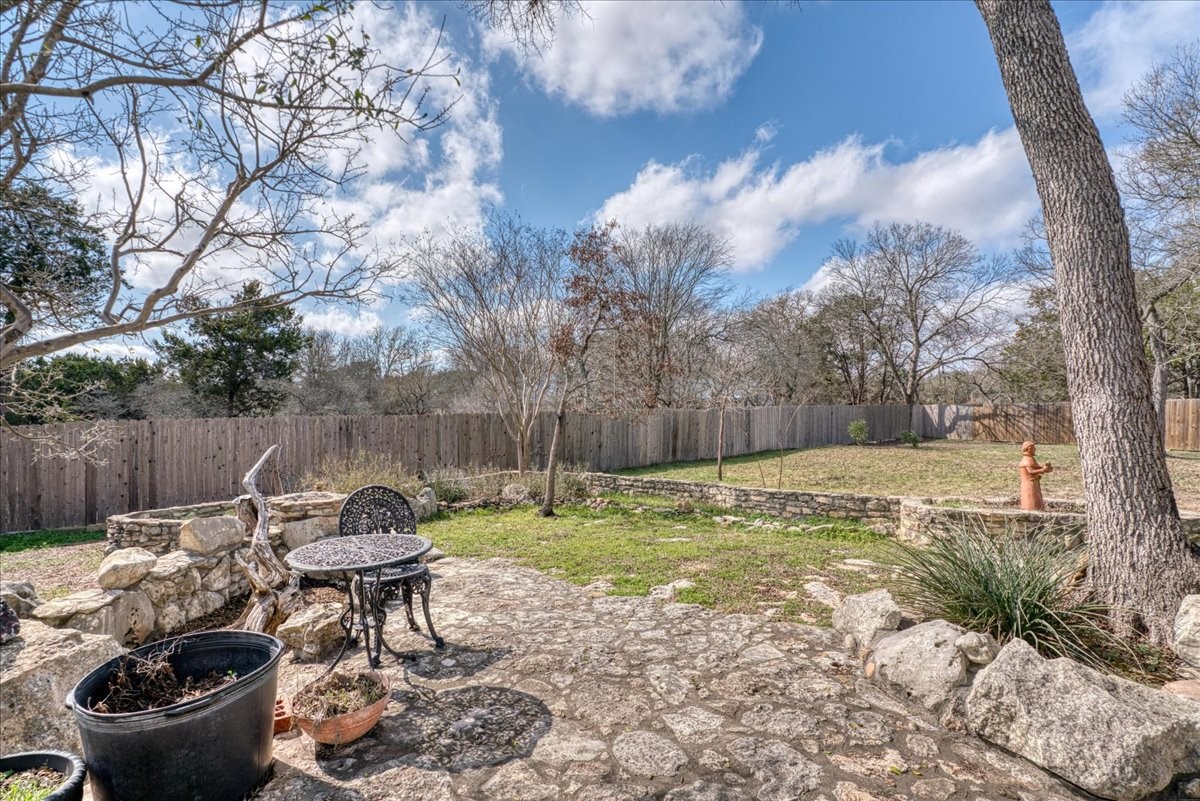 20 Saddle Rock Ridge Street Wimberley, TX 78676 - Photo 32 of 40 a view of a backyard with table and chairs and a fire pit
