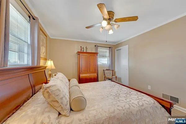 a bedroom with a large bed and ceiling fan