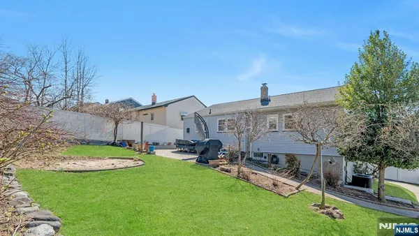 a view of a house with backyard and a tree
