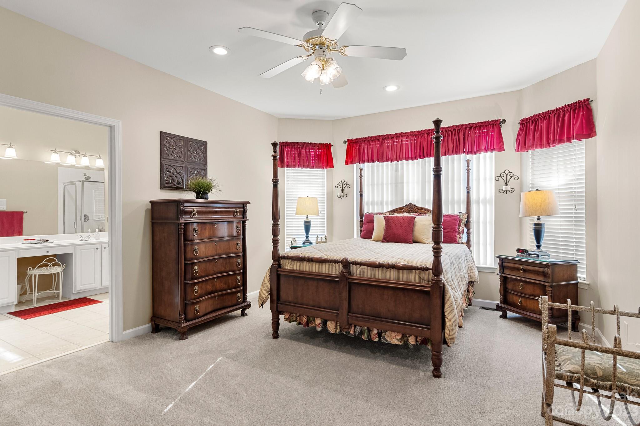 741 Knightswood Road Fort Mill, SC 29708 - Photo 23 of 47 a bedroom with a bed a couch and a chandelier