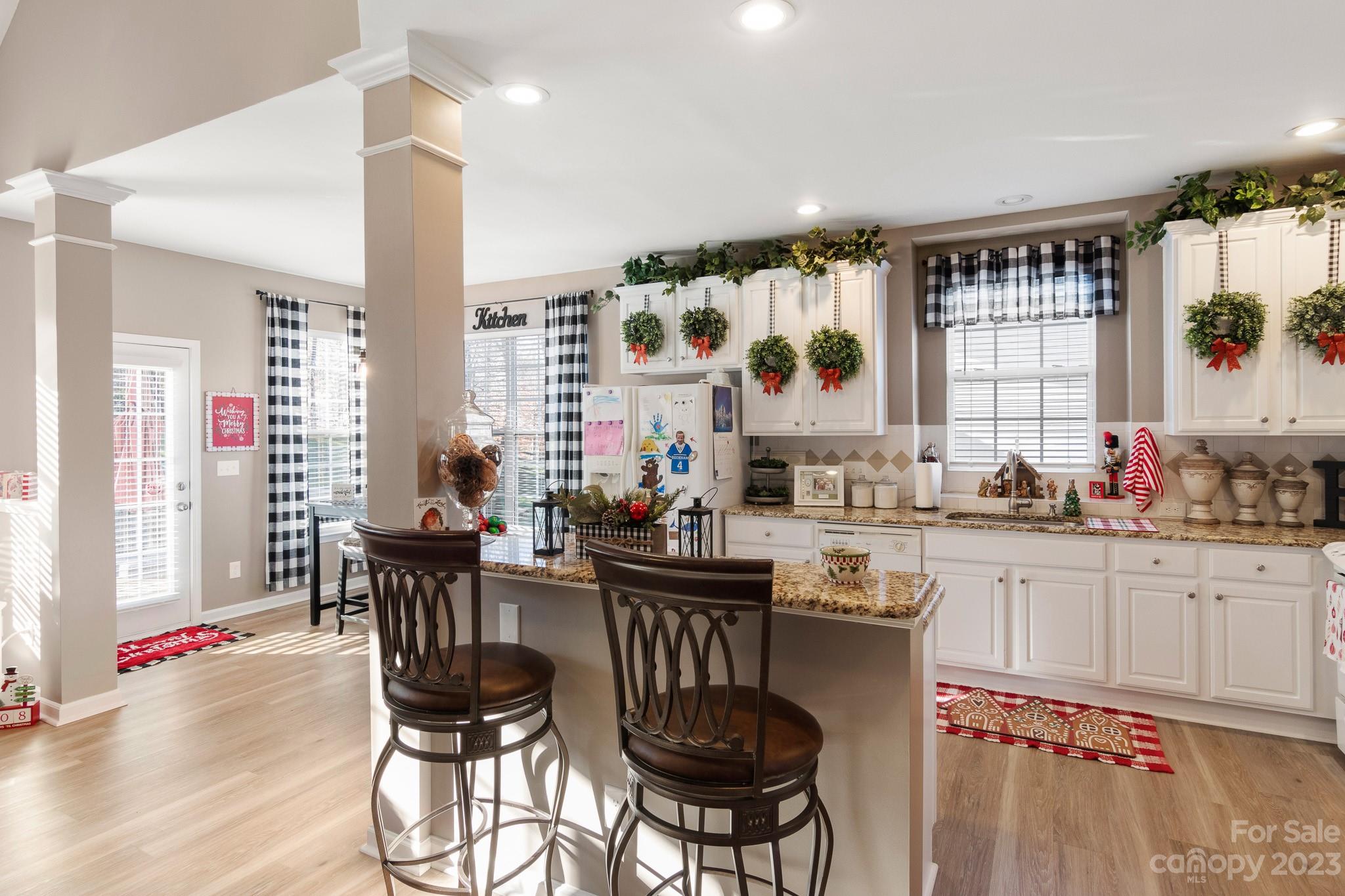 741 Knightswood Road Fort Mill, SC 29708 - Photo 10 of 47 a kitchen with stainless steel appliances granite countertop a stove a sink dishwasher a dining table and chairs with wooden floor