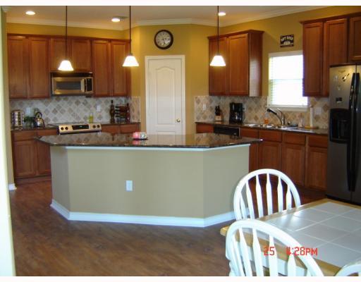 7526 Bell Isle Corpus Christi, TX 78414 - Photo 3 of 7 a kitchen with stainless steel appliances granite countertop a stove a sink a microwave a refrigerator and island
