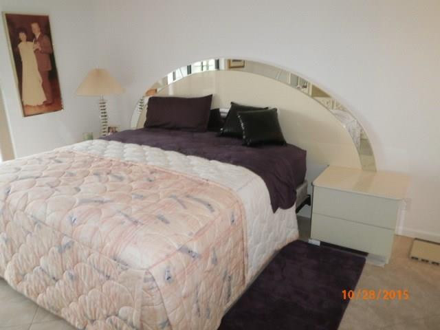 8431 Parkgate Road, Unit 8431 Boca Raton, FL 33496 - Photo 13 of 21 a bed sitting in a bedroom next to a lamp