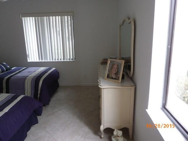 8431 Parkgate Road, Unit 8431 Boca Raton, FL 33496 - Photo 16 of 21 a bed sitting in a bedroom next to a window