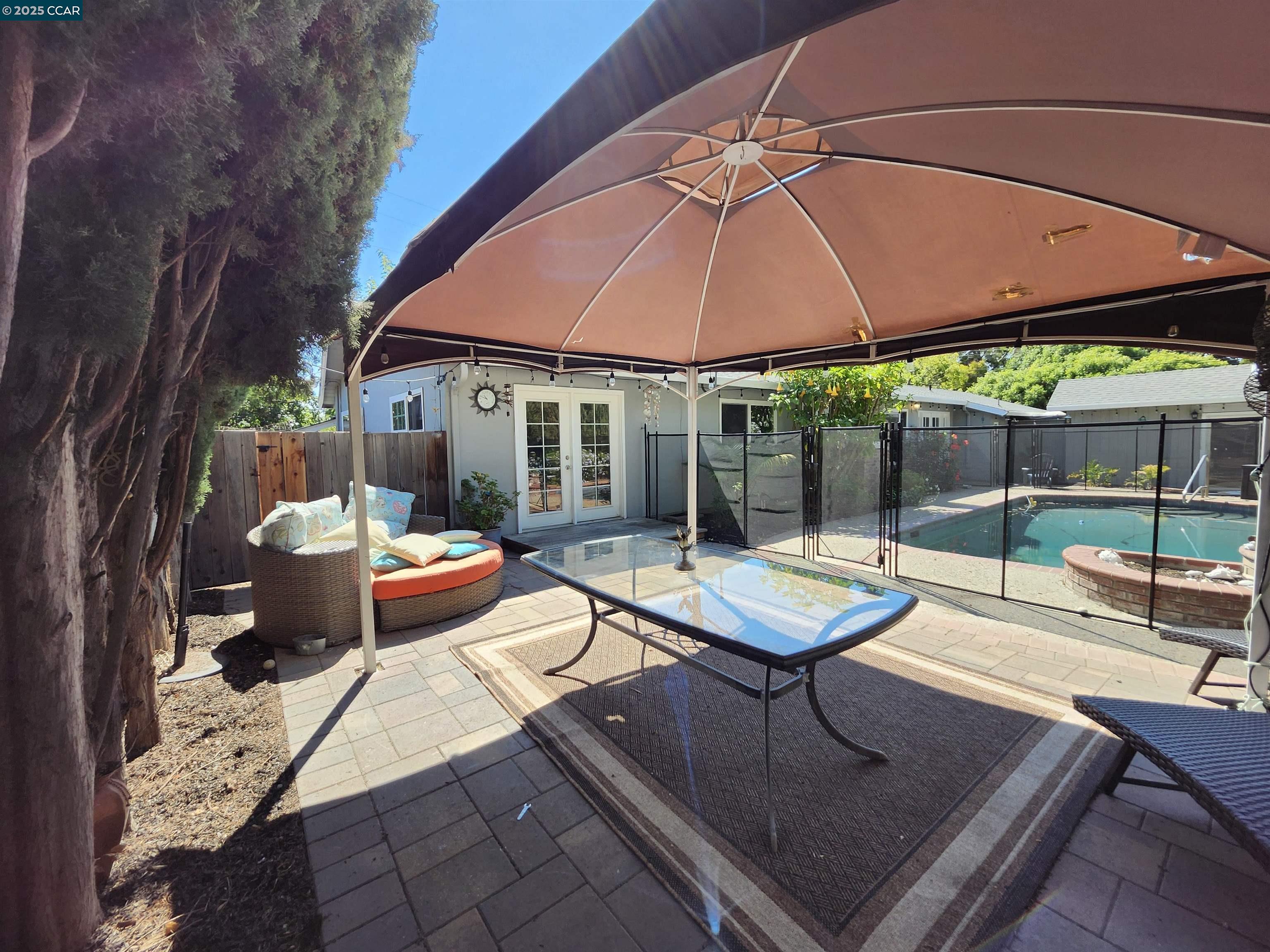 3479 Rose Court Concord, CA 94519 - Photo 37 of 60 a patio with a table and chairs under an umbrella