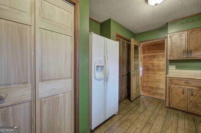 a kitchen with white cabinets and wooden floor