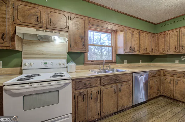 a kitchen with granite countertop cabinets stainless steel appliances and a sink
