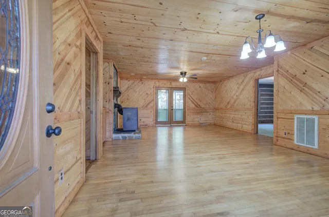 a view of a hallway with wooden floor and a chandelier