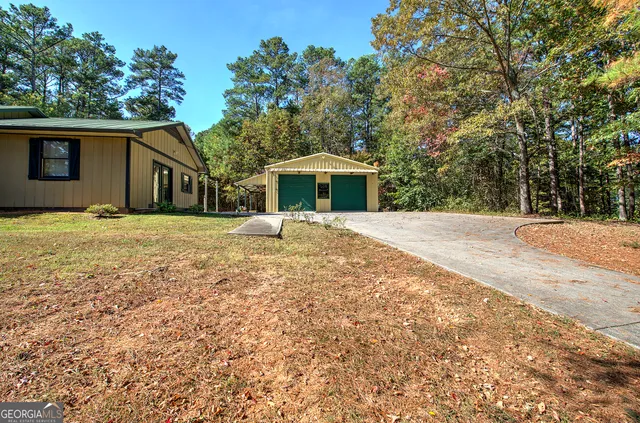a view of a white house with a yard and potted plants