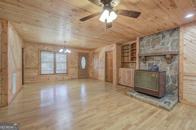 a view of a room with wooden floor and a ceiling fan