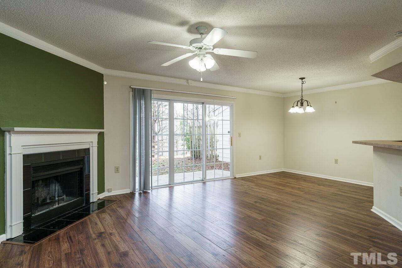 7906 Falcon Rest Circle Raleigh, NC 27615 - Photo 2 of 20 an empty room with wooden floor fireplace and windows