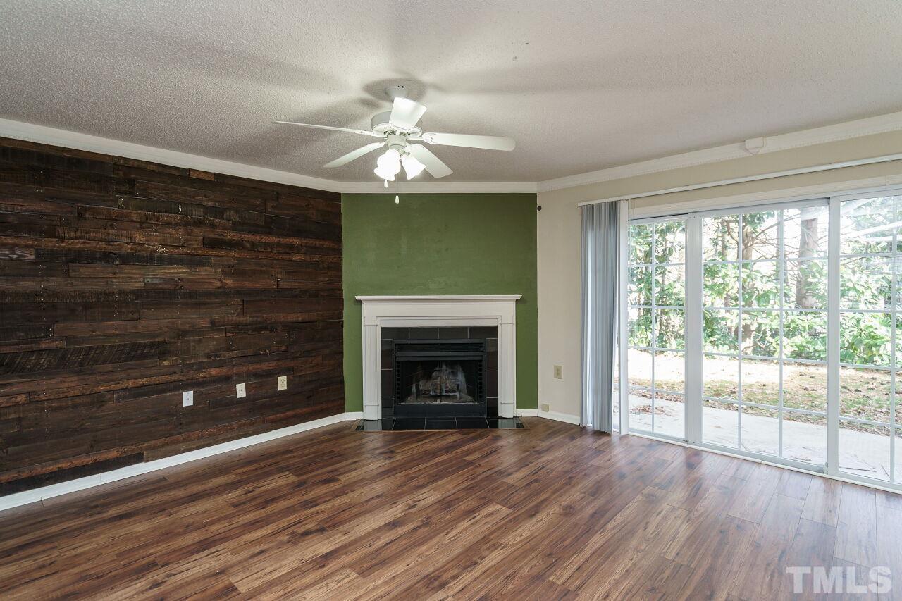 7906 Falcon Rest Circle Raleigh, NC 27615 - Photo 3 of 20 a view of an empty room with wooden floor fireplace and a window